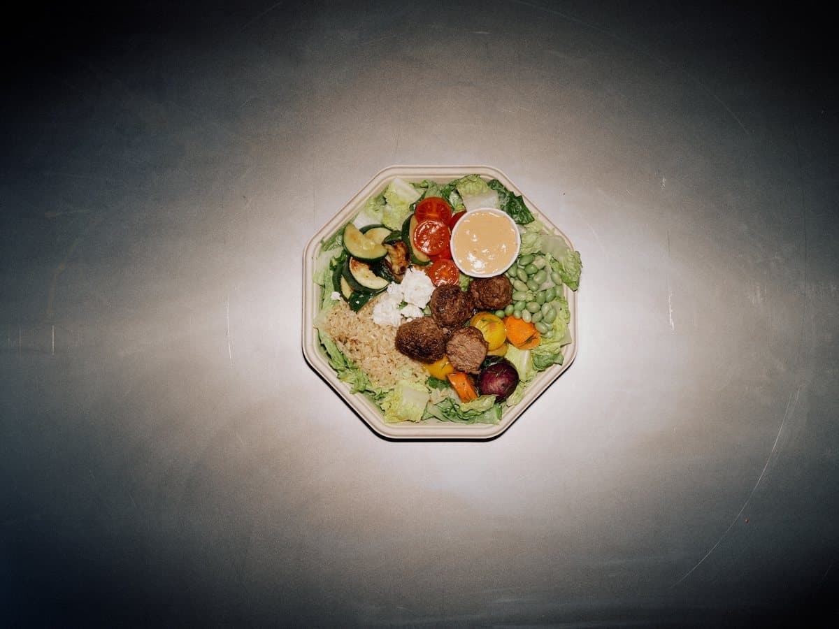Iron Wo Man plate with smoky meatball, pomegranate, feta, zucchini, and chipotle