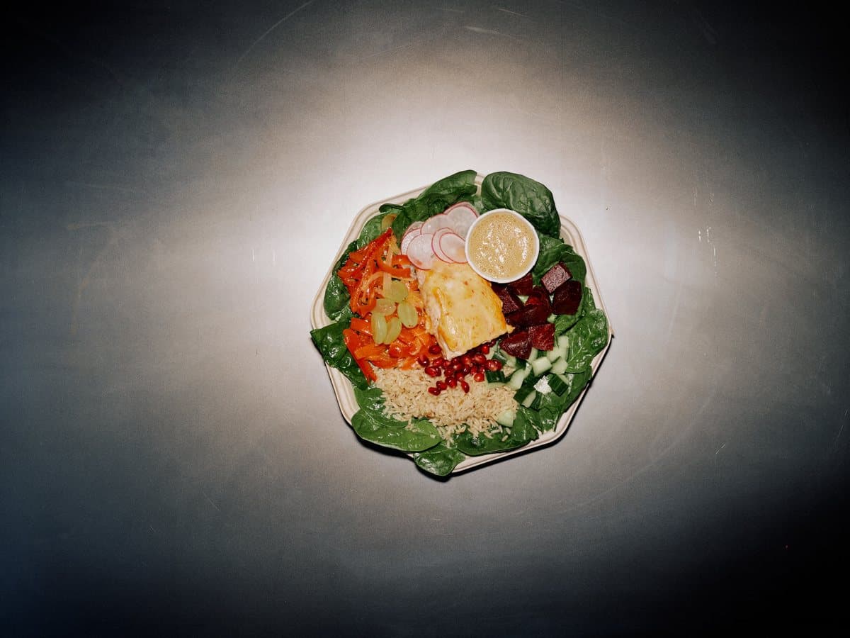 Daily Juggles plate with miso glazed fish, grapes, avocado, radish, and honey