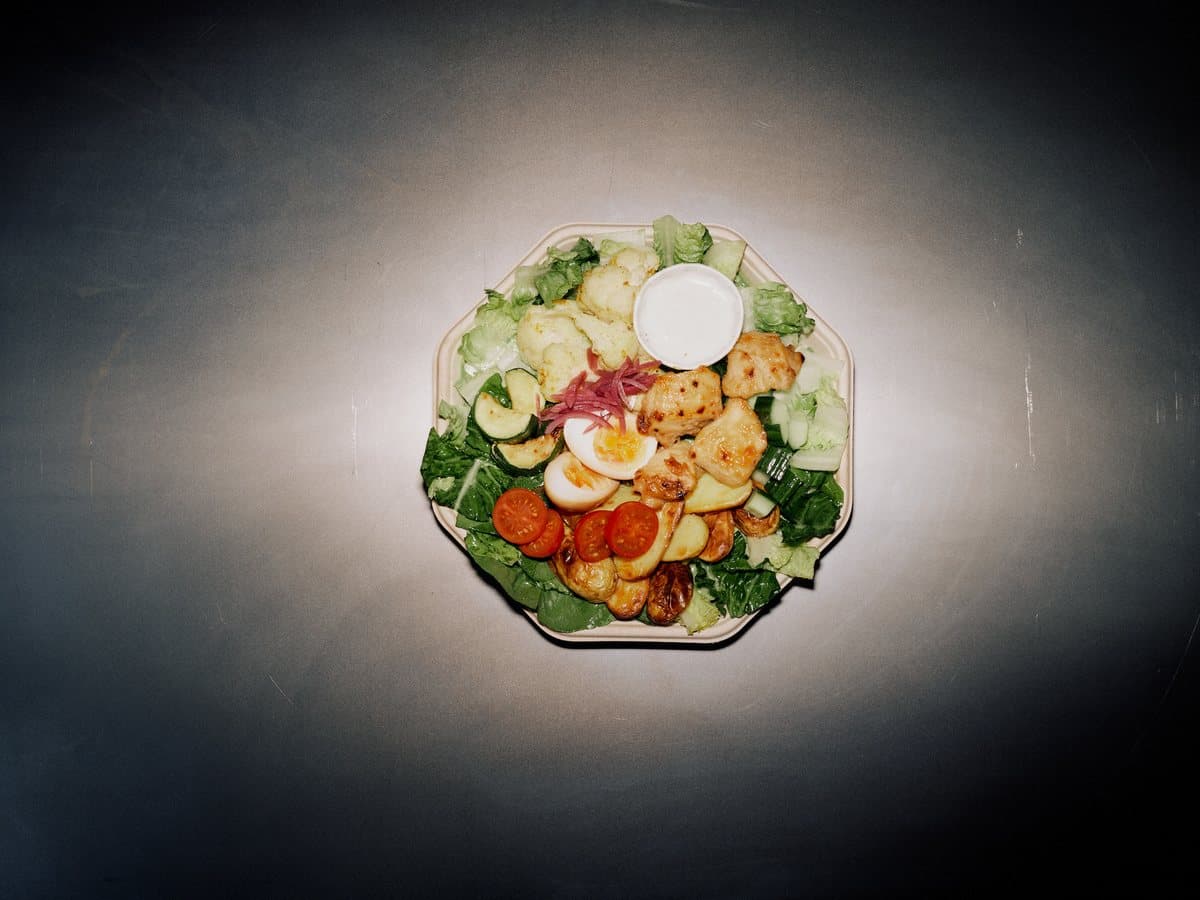 Push Your Boundaries plate with crispy chicken Caesar, potatoes, ramen egg, and onions